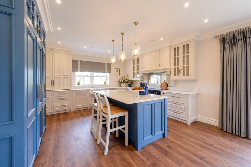 Open-plan kitchen featuring blue island cabinetry and classic white units – Cloyne Farmhouse Part One project, designed by AK Interior, Cork, Ireland.