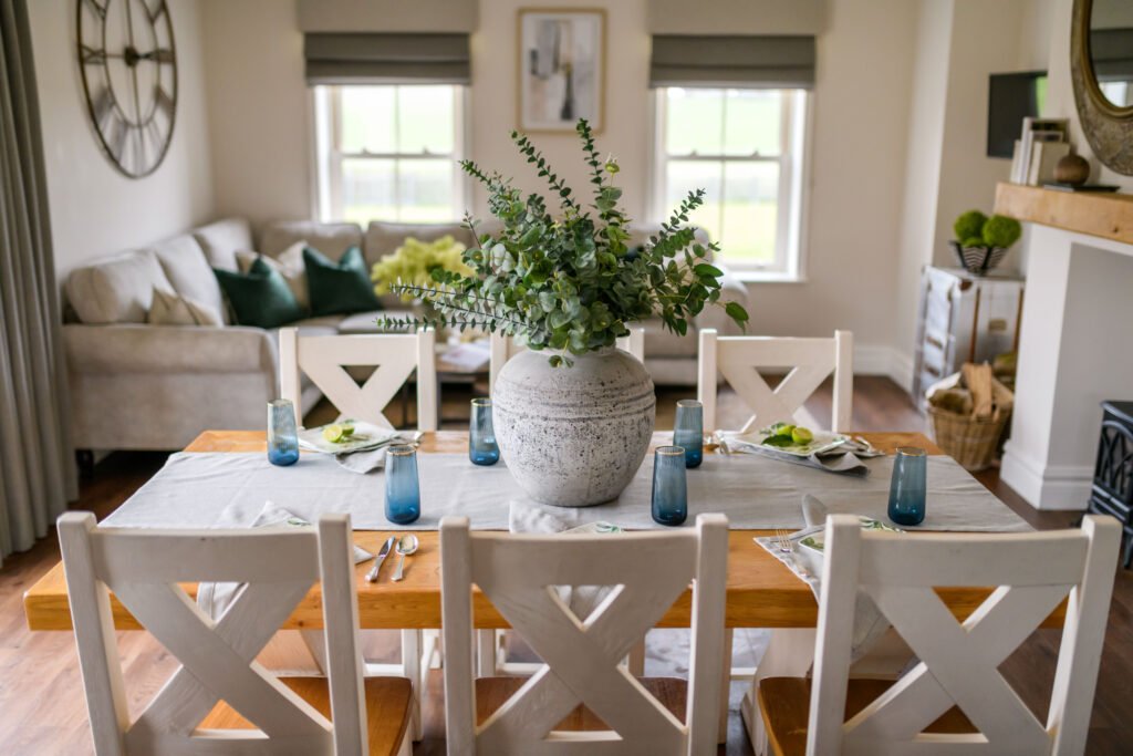 Living room view with L-shaped sofa, floral decor and layered neutrals – Residential project “Cloyne Farmhouse Part One”, designed by AK Interior, Cork, Ireland.