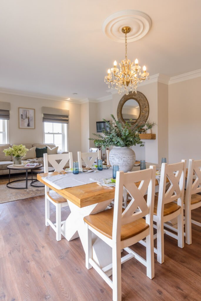 Dining area featuring large ceramic centerpiece with greenery and view into living room – Residential project “Cloyne Farmhouse Part One”, designed by AK Interior, Cork, Ireland.