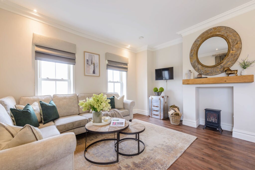 Living room with neutral sofa, fireplace and styled round coffee table – Cloyne Farmhouse Part One project, designed by AK Interior, Cork, Ireland.