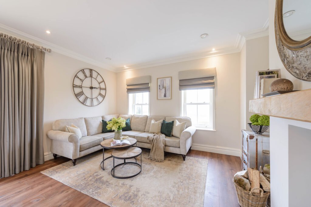 Bright living room with corner sofa, round coffee table and large decorative mirror – Cloyne Farmhouse Part One project, designed by AK Interior, Cork, Ireland.