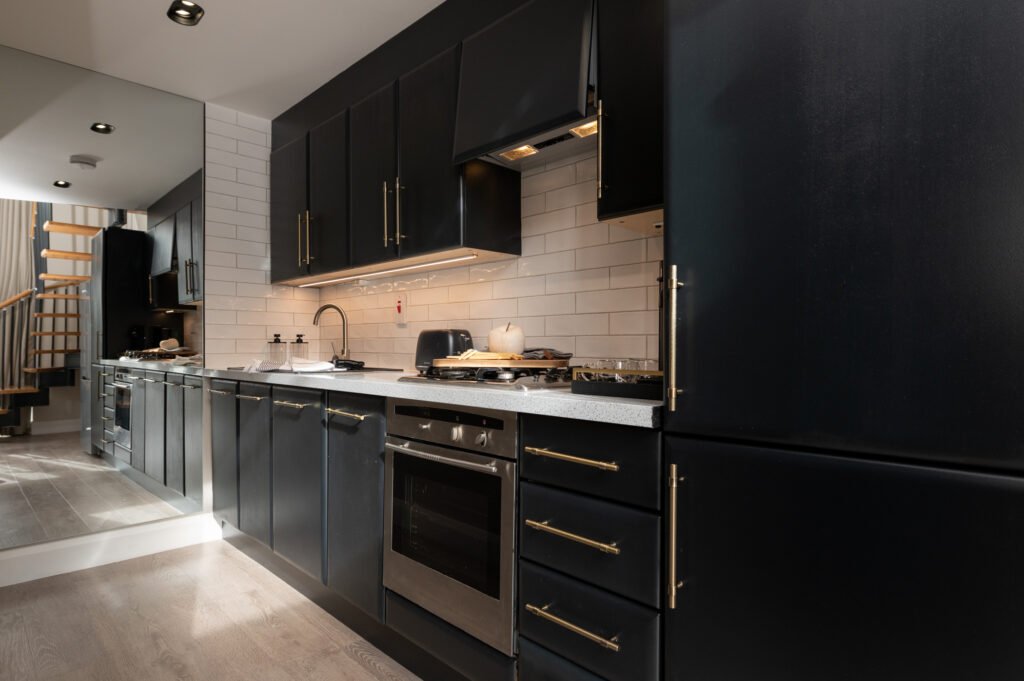 Dark modern kitchen with black cabinetry and light countertop. West Cork Waterfront project by AK Interior, Cork, Ireland.