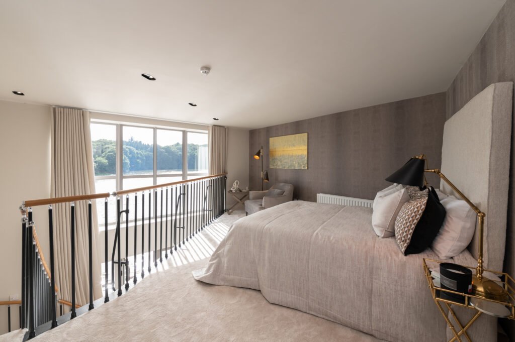 Bedroom lounge corner with armchair, wall painting and side table. West Cork Waterfront project by AK Interior, Cork, Ireland.