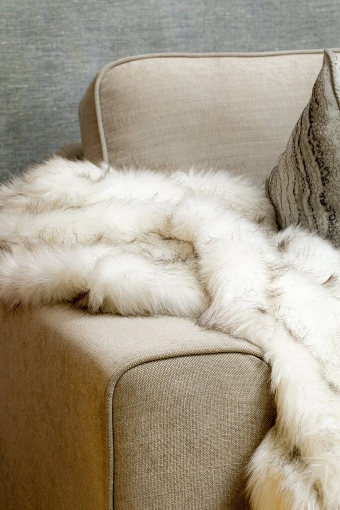 Light sofa corner draped with a white fur throw – Blarney Residential, AK Interior, Cork