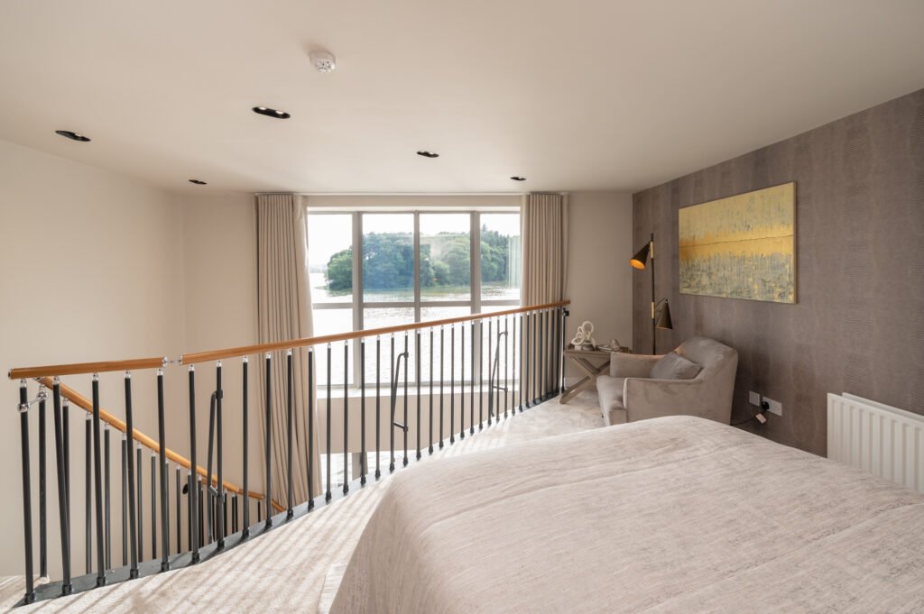Bedroom with large bed and glass doors opening to balcony – Wharf Penthouse, residential project by AK Interior, Cork, Ireland.