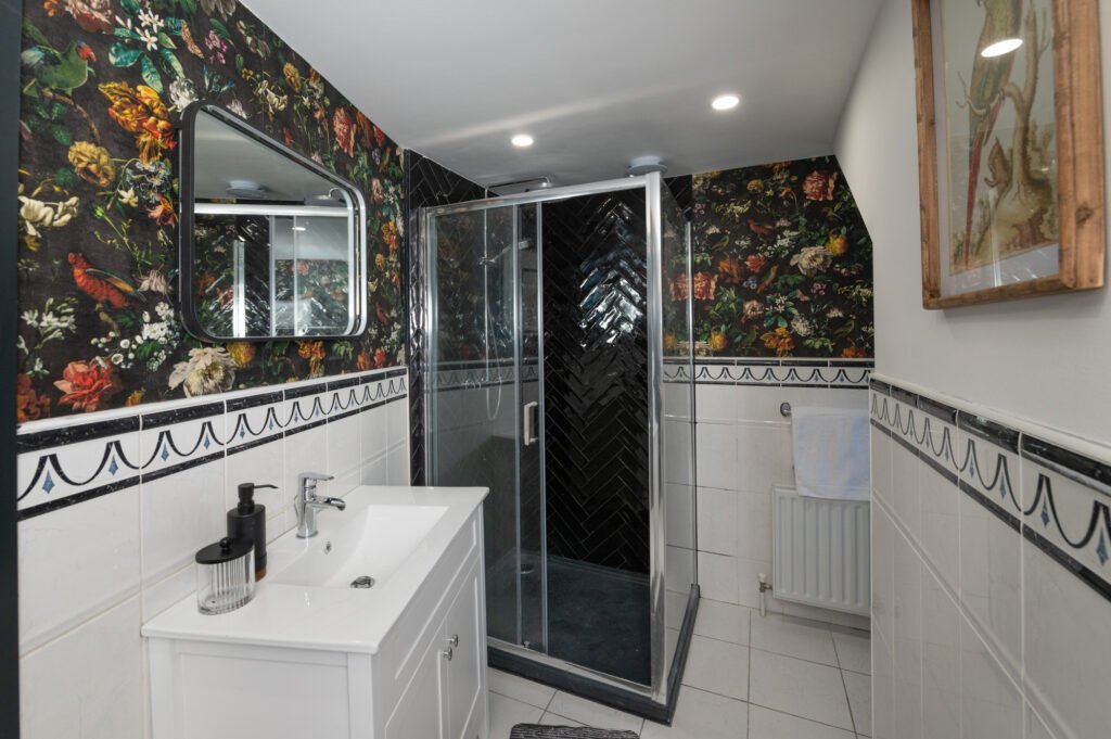 Bathroom with patterned feature wall and wall-mounted mirror – Wharf Penthouse, residential project by AK Interior, Cork, Ireland.