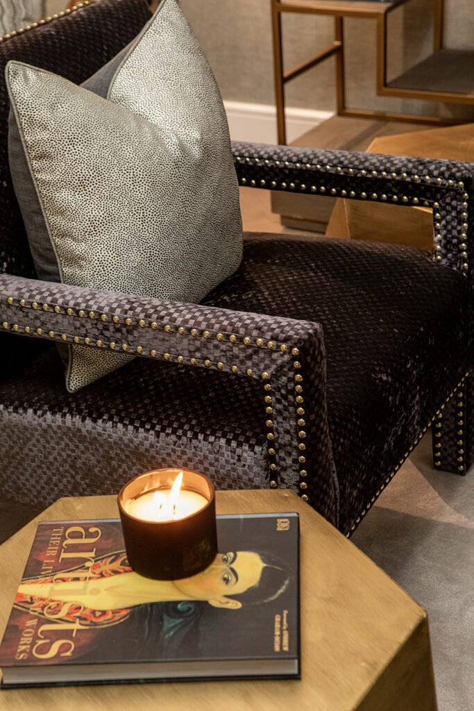Armchair with gold studs and a cushion beside a lit candle on a side table – Blarney Residential, AK Interior, Cork