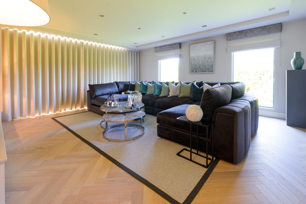 Panoramic view of living room with modular sofa, round coffee tables and full-height glazing, Rathmore Residential project, AK Interior, Cork.