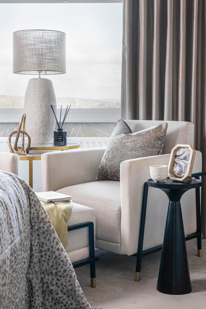 Close-up of armchair with patterned throw and black pedestal side table – Douglas Part One project, designed by AK Interior, Cork, Ireland.