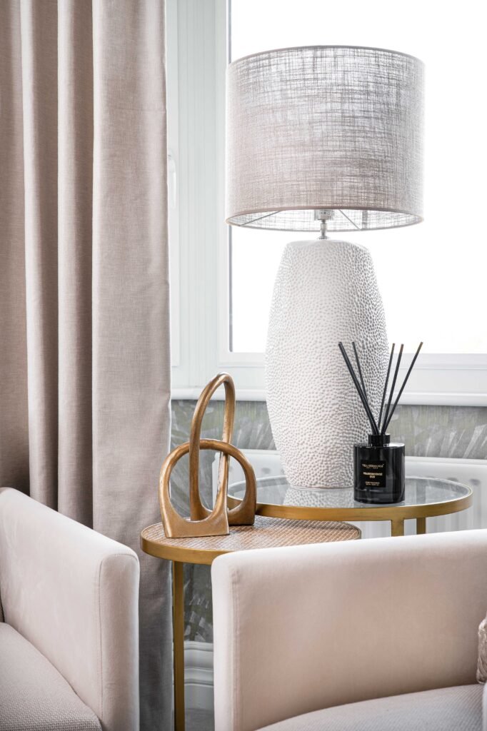 Soft beige armchair with round gold side table and textured lamp – Douglas Part One project, designed by AK Interior, Cork, Ireland.
