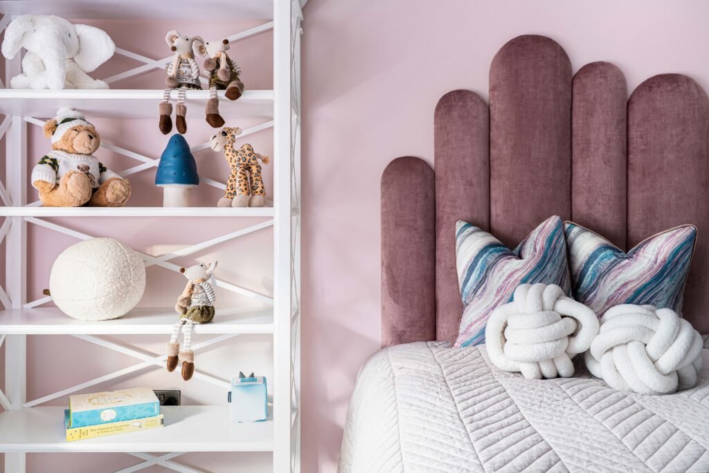 Kid’s room with curved blush headboard, colourful cushions and toy shelf – Douglas Part One project, designed by AK Interior, Cork, Ireland.