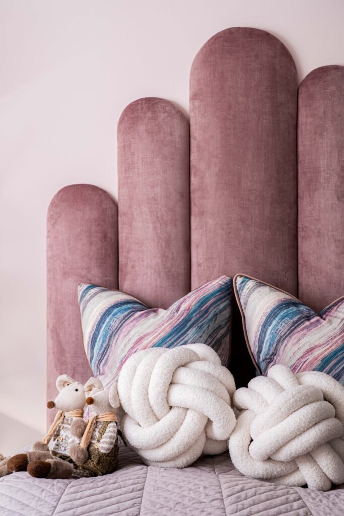 Blush pink headboard with playful décor and stuffed toys – Douglas Part One project, designed by AK Interior, Cork, Ireland.
