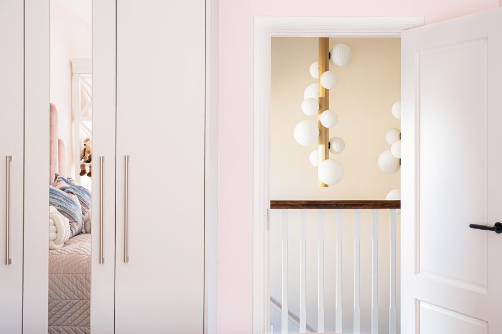 Soft pink children’s room with modern ceiling light and decorative shelving – Douglas Part One project, designed by AK Interior, Cork, Ireland.