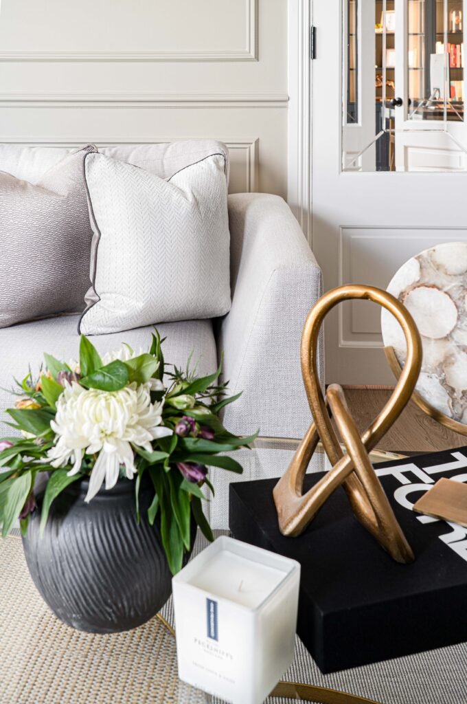 Coffee table styled with a flower vase, candle, and gold sculpture – Douglas Part Two, AK Interior, Cork