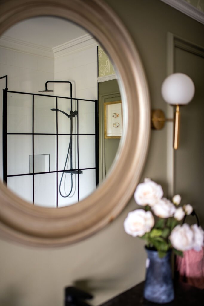 Round mirror reflecting black-framed glass shower enclosure – Cloyne Farmhouse Part Two project, designed by AK Interior, Cork, Ireland.