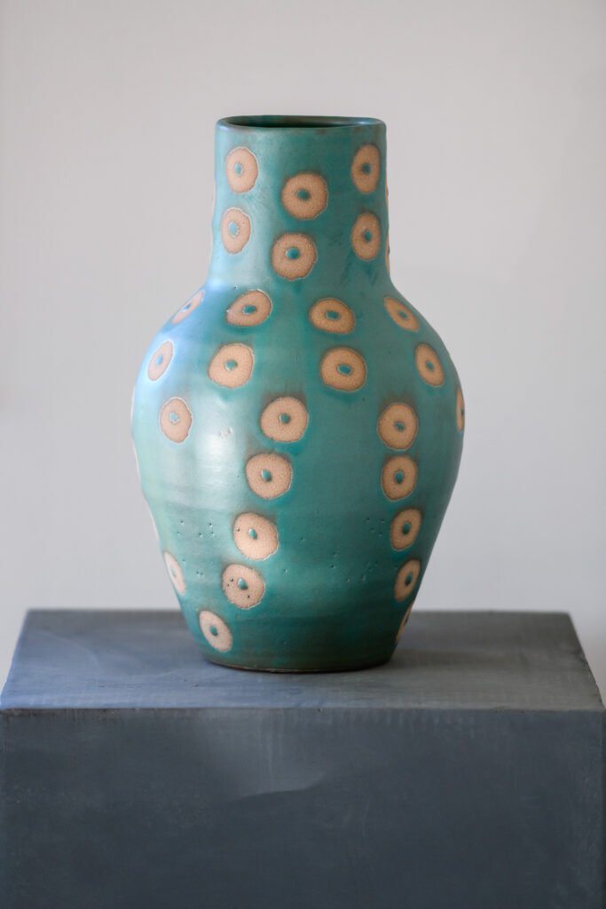 Portrait view of turquoise spot-pattern vase on dark plinth, Rathmore Residential project, AK Interior, Cork.