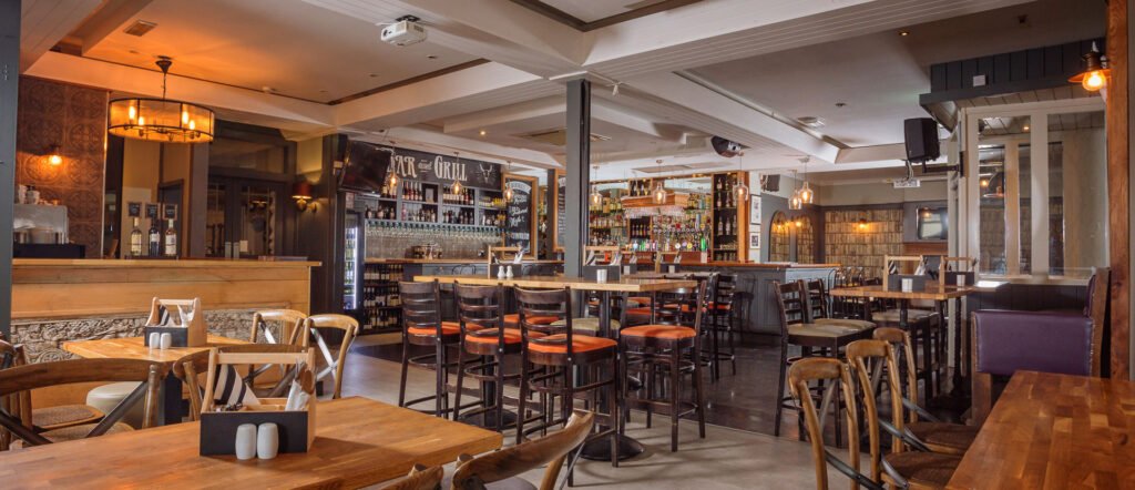 Warm bar and restaurant interior with timber ceiling, open seating and feature back bar. Briar Rose Commercial project, AK Interior, Cork.