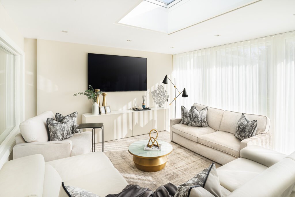 Bright living room with cream sofas, large windows and patterned cushions – Moneygurney Road Part One by AK Interior.