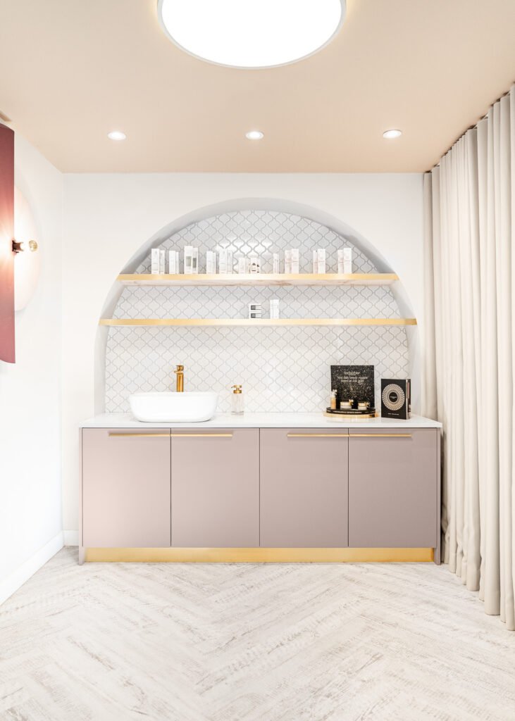 Built-in arched shelving with beauty products and gold accents – Bon Me project, designed by AK Interior Cork.