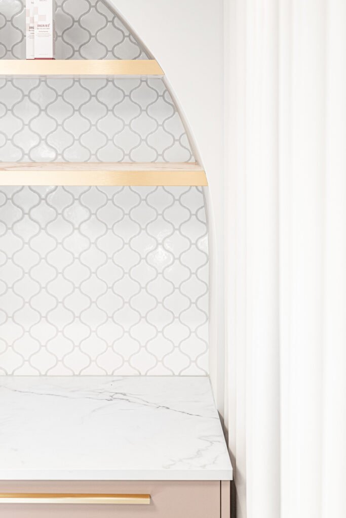 Arched shelving wall with textured white tiles and gold details – Bon Me project, designed by AK Interior Cork.