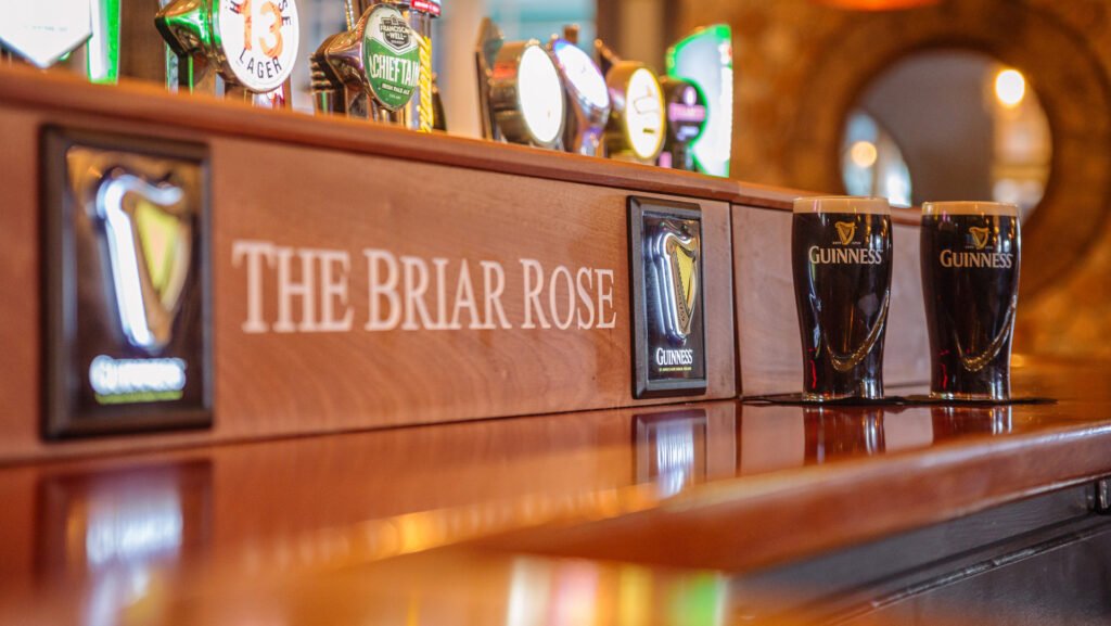 Bar counter detail with beer taps, branded signage and bottle display. Briar Rose Commercial project, AK Interior, Cork.