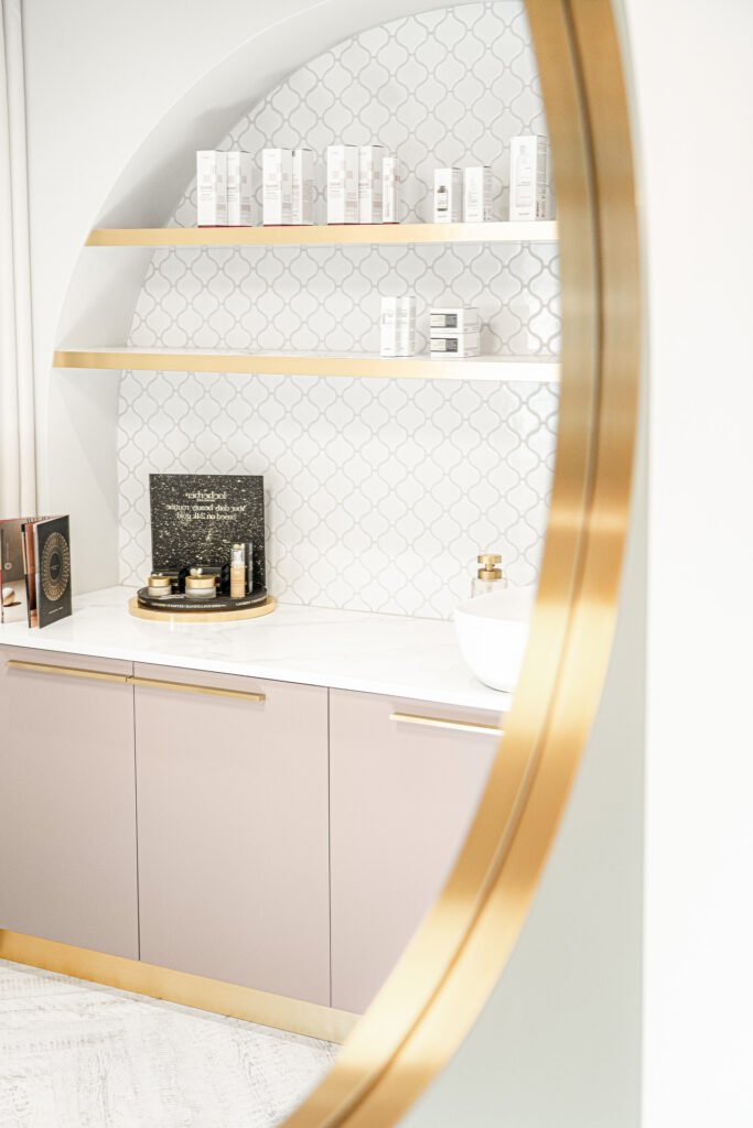 Round gold-framed mirror with a soft pink wall light – Bon Me project, designed by AK Interior Cork.