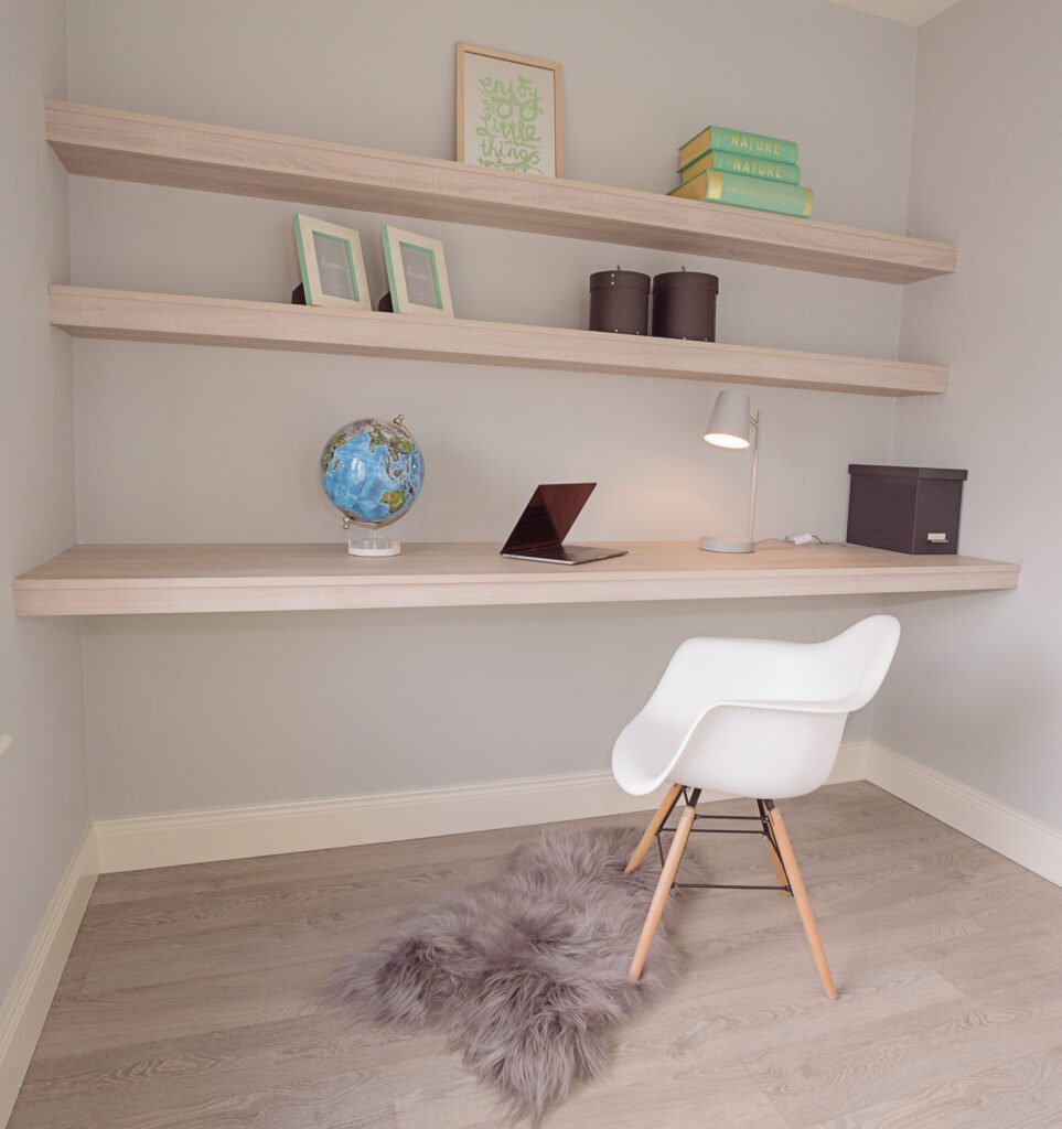 Minimalist home office corner with floating shelves, white chair and decorative accents – Innishannon Showhouse by AK Interior, Cork Ireland.