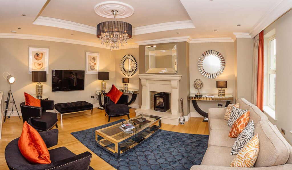 Wide-angle of living room with crystal chandelier, blue rug and mirrored coffee table. Rockport Residential project, AK interior.