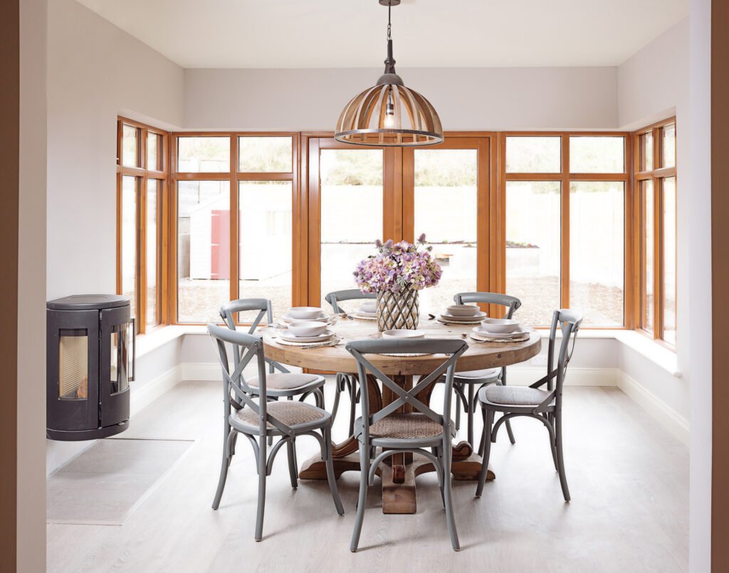 Dining area with round table, wooden chairs and large windows – Innishannon Showhouse by AK Interior, Cork, Ireland