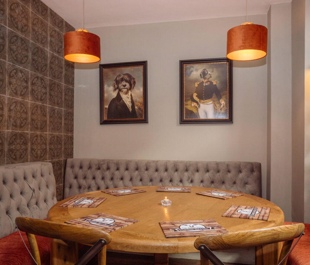 Round table with upholstered chairs and copper drum pendant above. Briar Rose Commercial project, AK Interior, Cork.