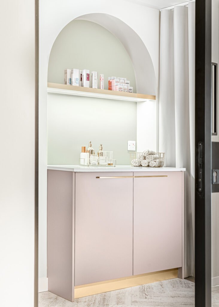 Arched vanity cabinet with beauty products and soft pastel cabinetry details – Bon Me project, designed by AK Interior Cork.