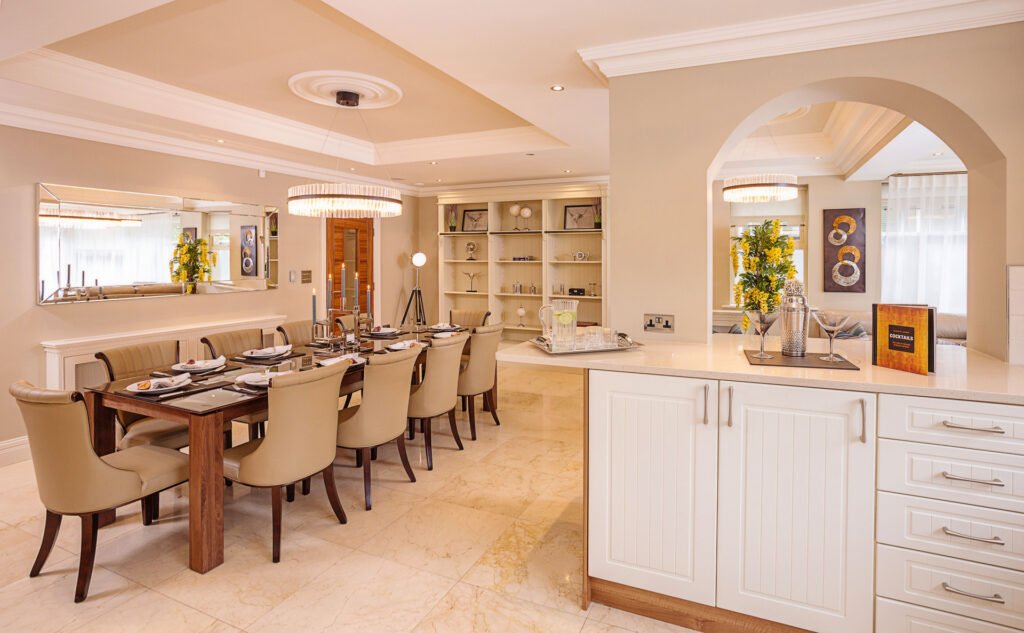 Open-plan kitchen and dining room with marble floor and cream cabinetry. Rockport Residential project, AK interior.