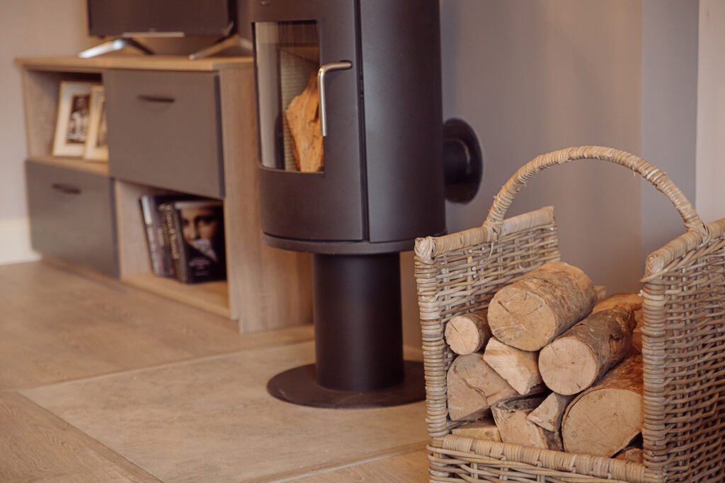 Wood-burning stove beside built-in shelving and decor accessories – Innishannon Showhouse by AK Interior, Cork Ireland.