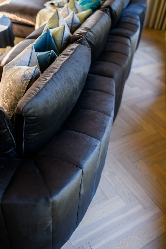 Back view of curved sectional sofa with layered cushions facing fireplace wall, Rathmore Residential project, AK Interior, Cork.