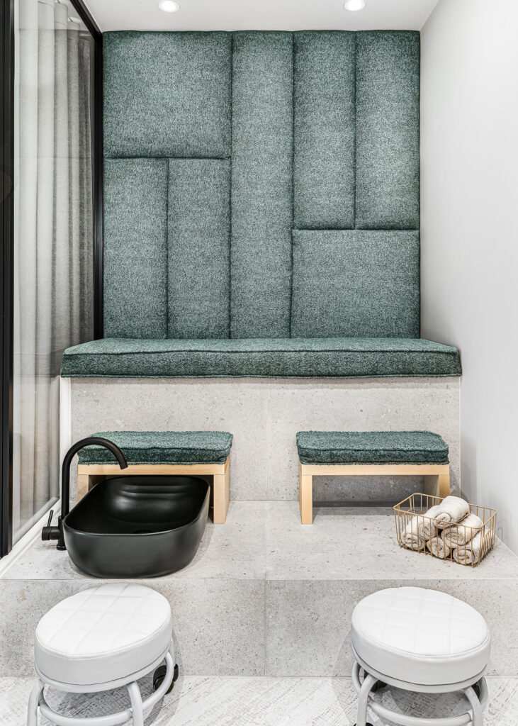 Pedicure station with green upholstered seating, wooden stools and black soaking bowl – Bon Me project, designed by AK Interior Cork.