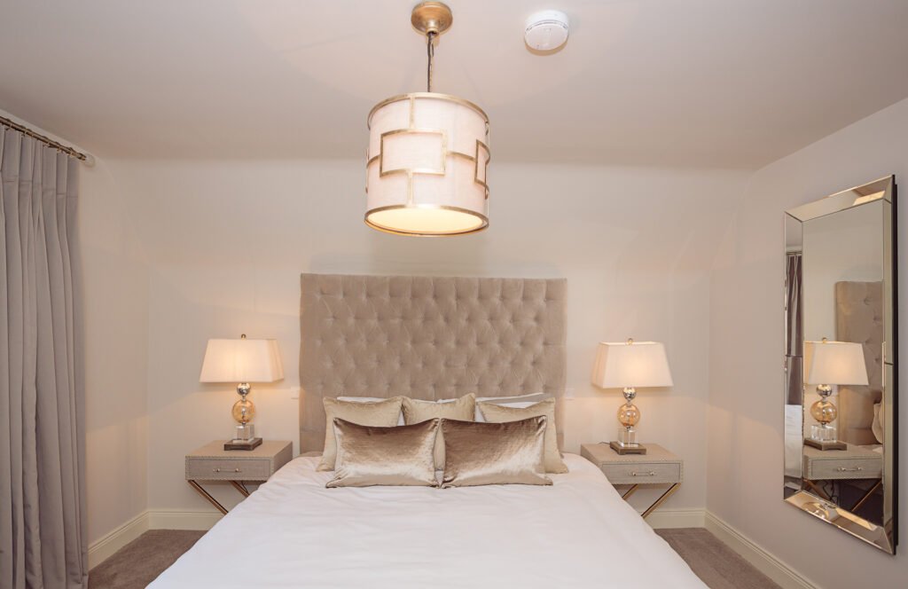 Neutral bedroom design with tufted headboard, matching bedside lamps and ceiling pendant light – Innishannon Showhouse by AK Interior, Cork Ireland.