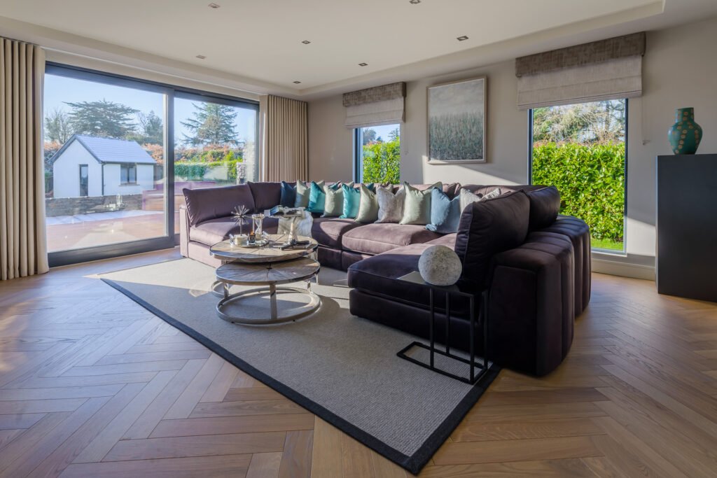 Contemporary living room with large corner sofa, twin round coffee tables and garden view, Rathmore Residential project, AK Interior, Cork.