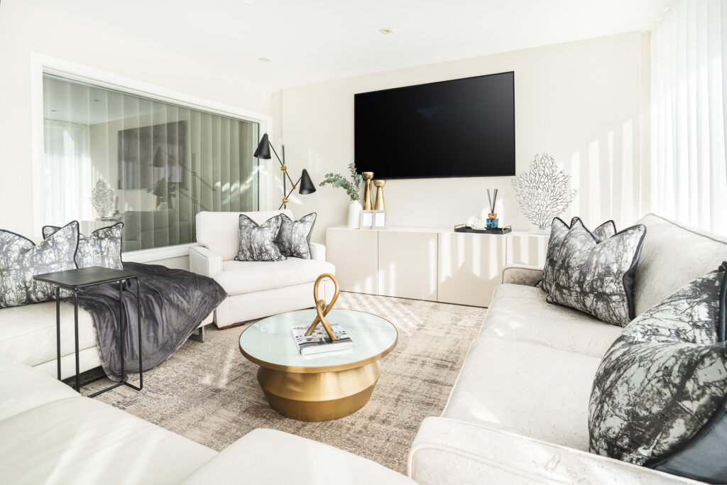 Bright living room with cream sofas, grey patterned cushions and a round coffee table – Moneygurney Road Part One by AK Interior.