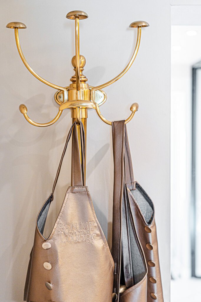Gold wall-mounted coat rack with salon aprons – Bon Me project, designed by AK Interior Cork.