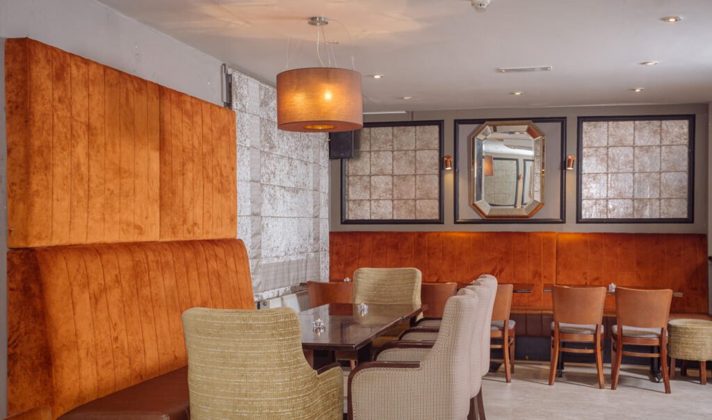 Cosy lounge corner with armchairs, textured walls and warm lighting. Briar Rose Commercial project, AK Interior, Cork.