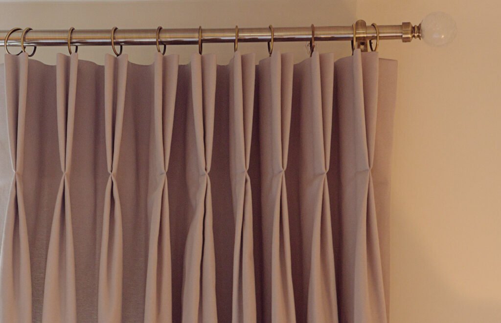 Pleated taupe curtains on metal curtain rod with clear finial – Innishannon Showhouse by AK Interior, Cork Ireland.