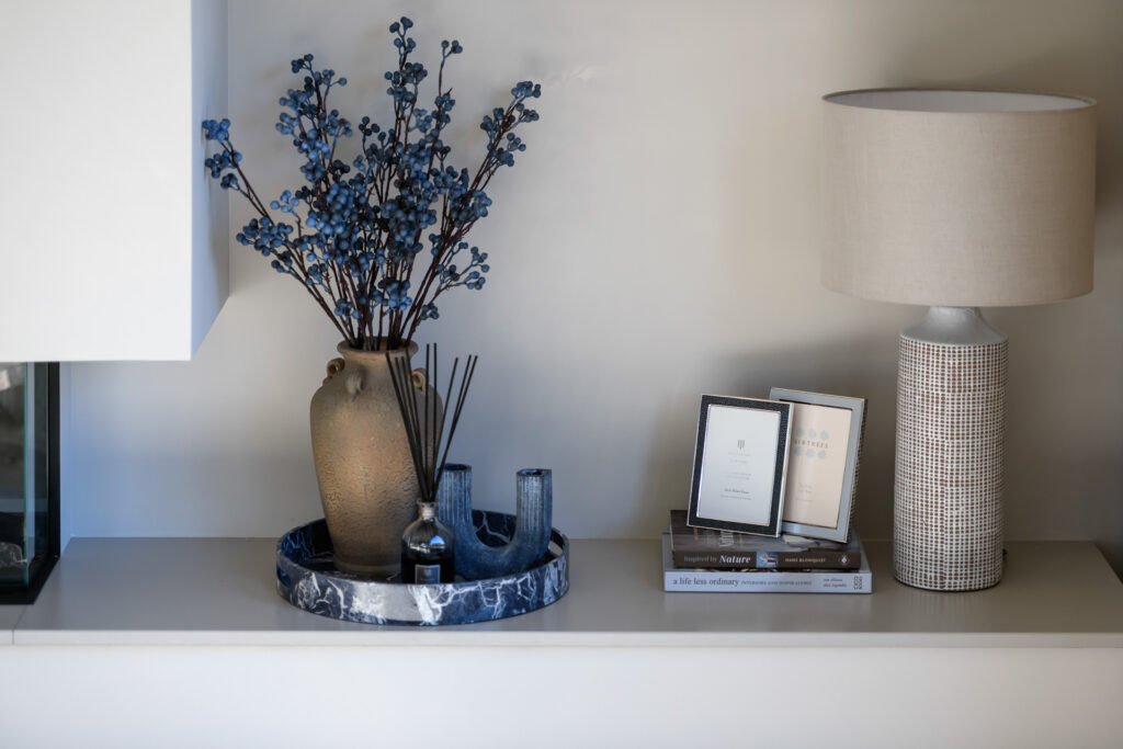 Shelf styling with ceramic vase, blue berry stems, framed photos and table lamp, Rathmore Residential project, AK Interior, Cork.