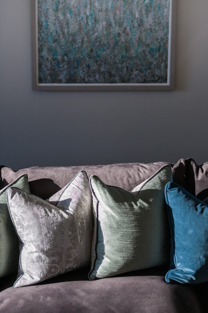 Sofa with layered teal and neutral cushions beneath abstract landscape painting, Rathmore Residential project, AK Interior, Cork.