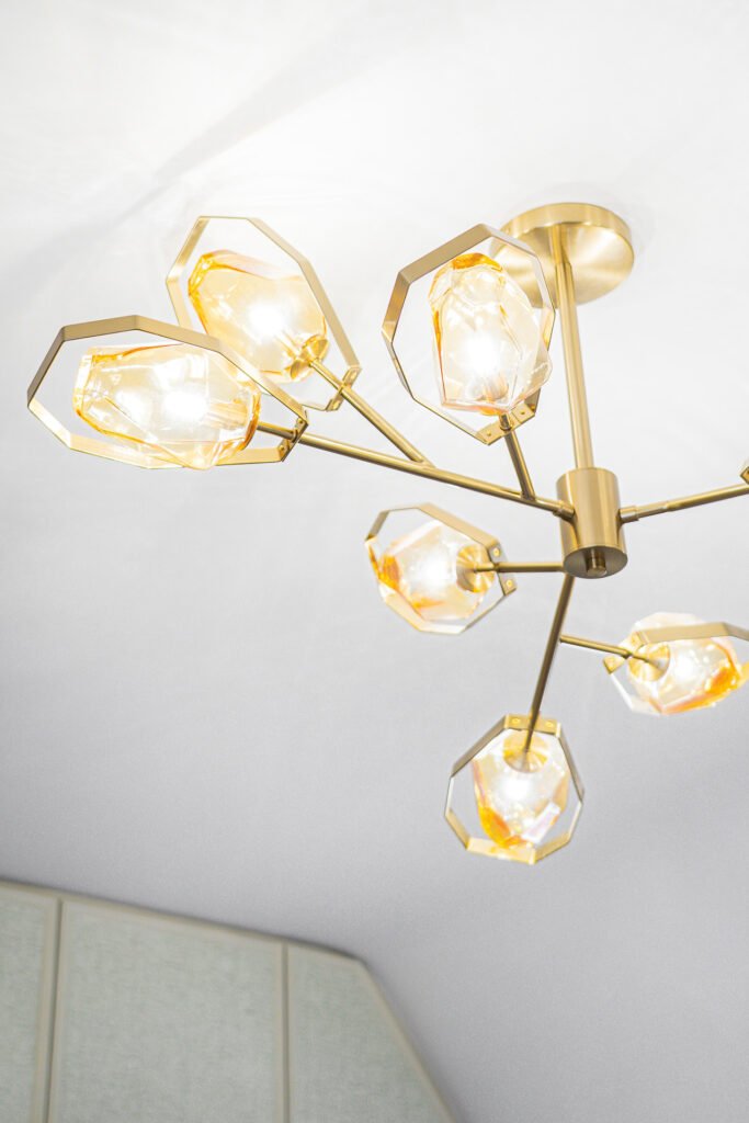 Golden multi-arm ceiling chandelier in the interior – Moneygurney Road Part One, AK Interior