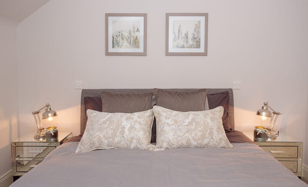Neutral bedroom with framed botanical artwork and taupe bedding – Innishannon Showhouse by AK Interior, Cork Ireland.
