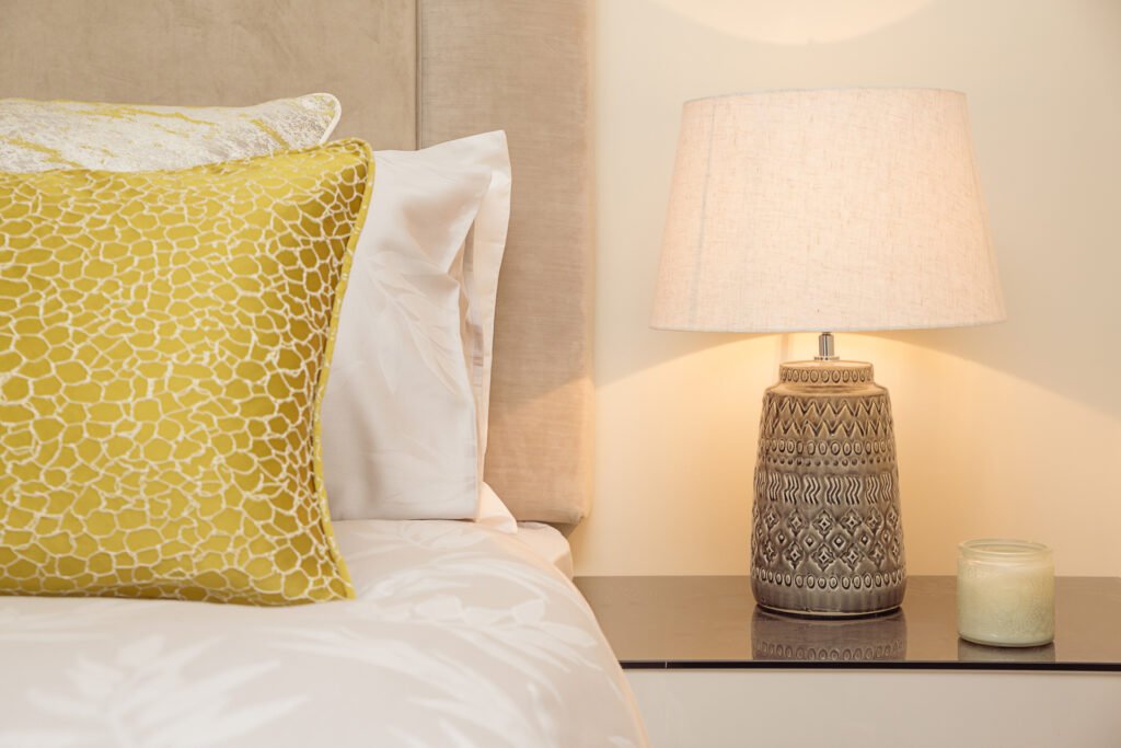 Close-up of yellow textured cushion and patterned ceramic bedside lamp – Innishannon Showhouse by AK Interior, Cork Ireland.