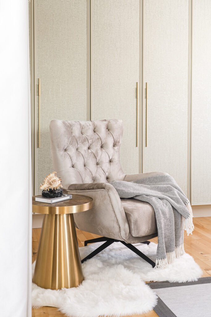 Beige tufted armchair beside a golden side table – Moneygurney Road Part One, AK Interior