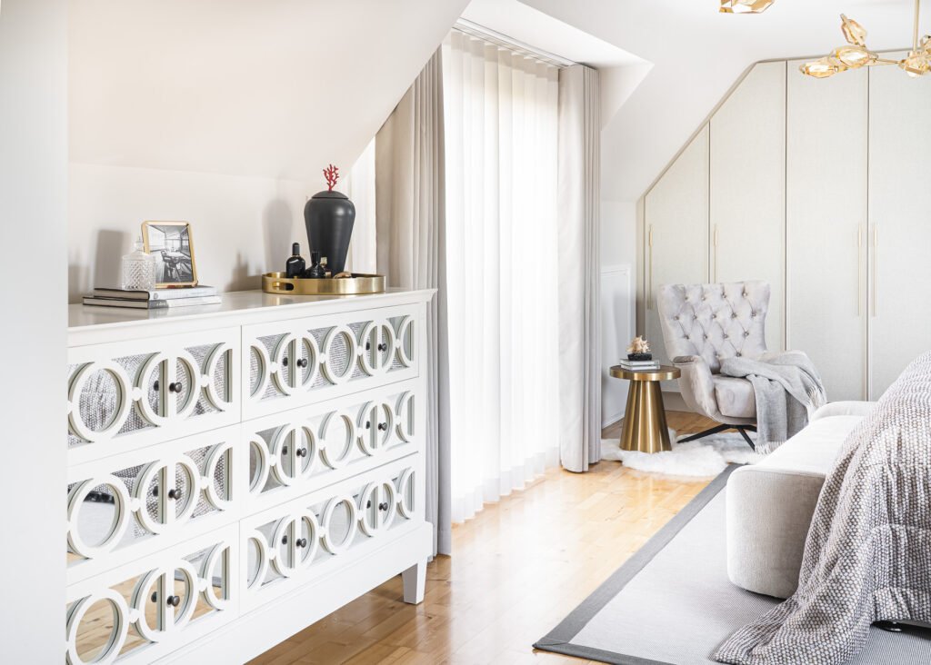 White decorative dresser with mirrored patterns and styling accessories beside a window with sheer curtains – Moneygurney Road Part One, AK Interior