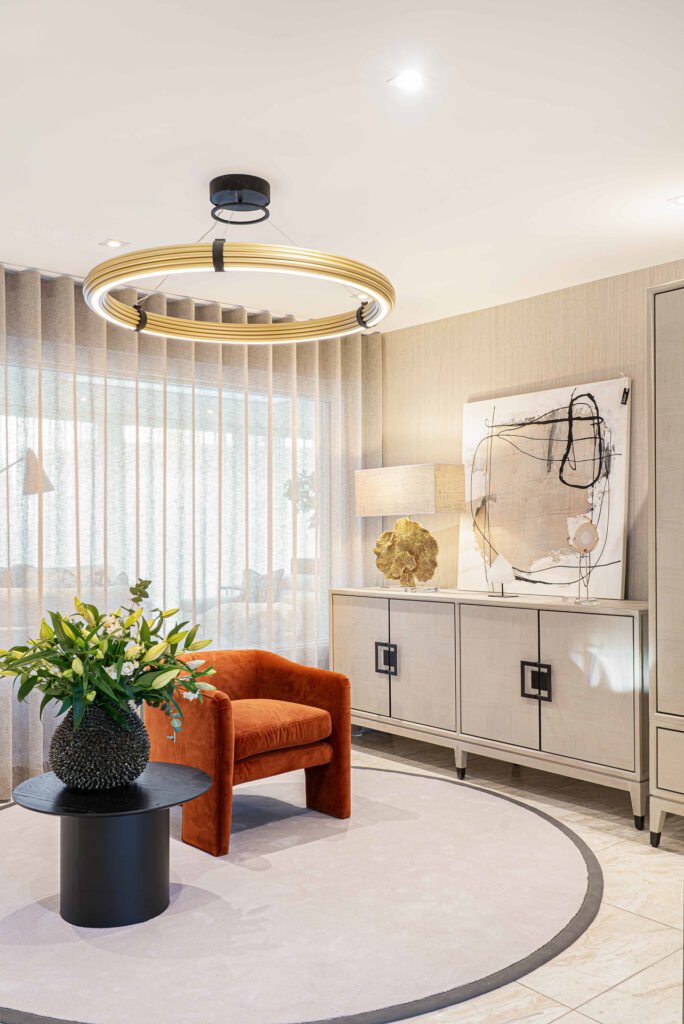 Modern living room with round rug, green plant and orange accent chair – Luxury Living Room Part Two by AK Interior.