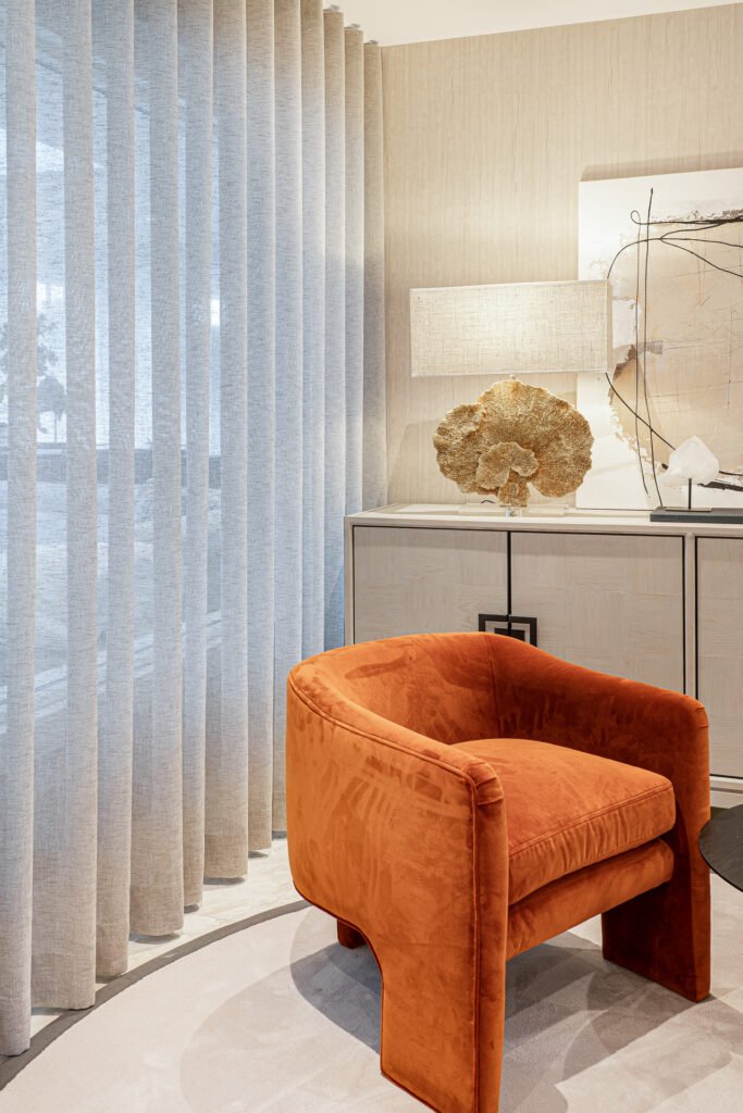 Orange velvet accent chair against soft curtain backdrop – Luxury Living Room Part Two by AK Interior.
